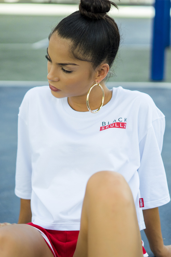 female model wearing white cropped t shirt with blackskullz logo