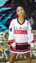 female wearing white hockey jersey with blackskullz logo and black and red embroidery