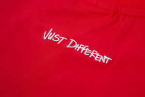 close up of just different white embroidery on red tshirt