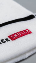 close up of blackskullz logo embroidery on white beanie
