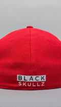 red fitted hat with embroidered black skullz logo